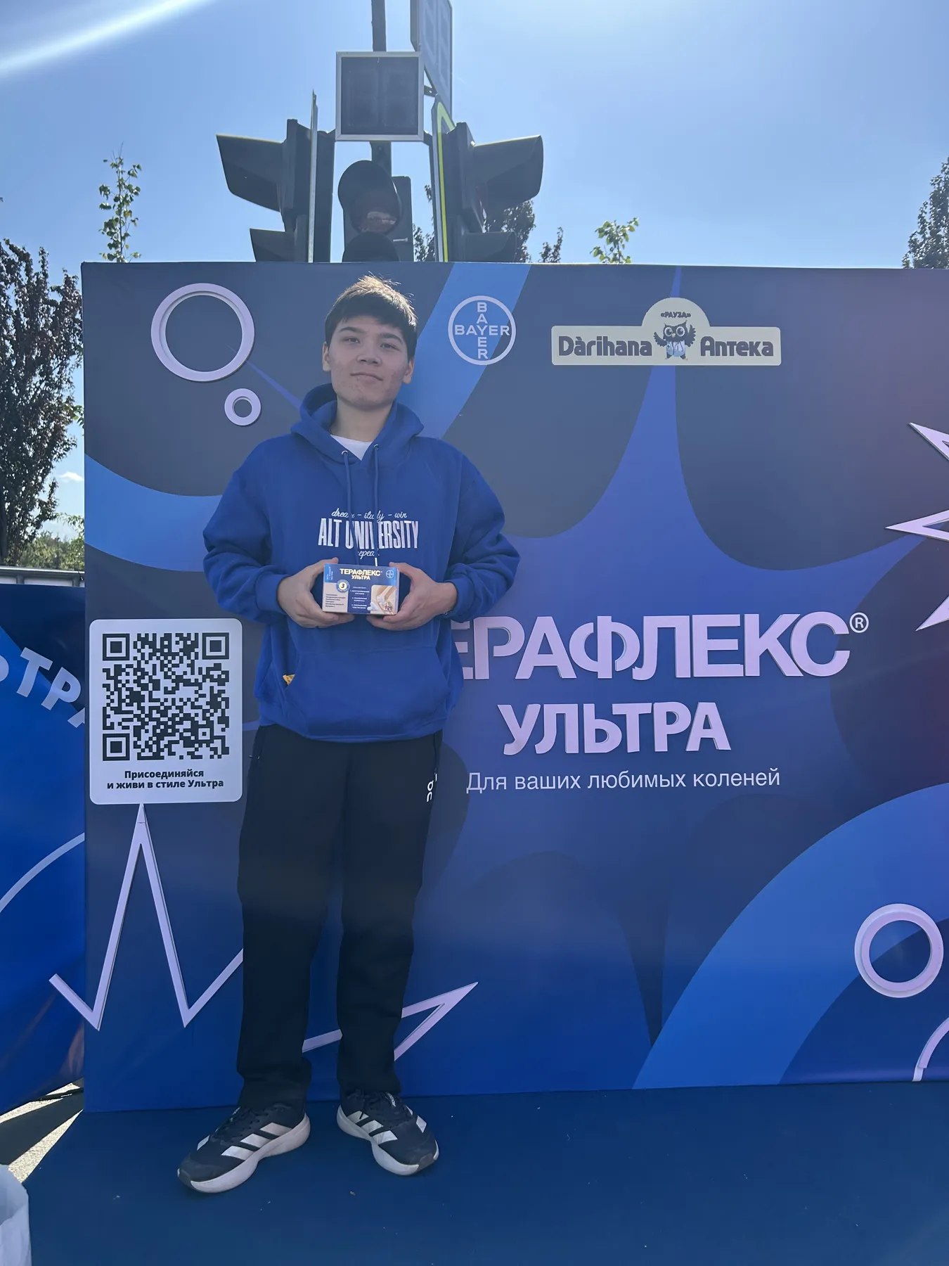 Победитель с призом на фоне стенда